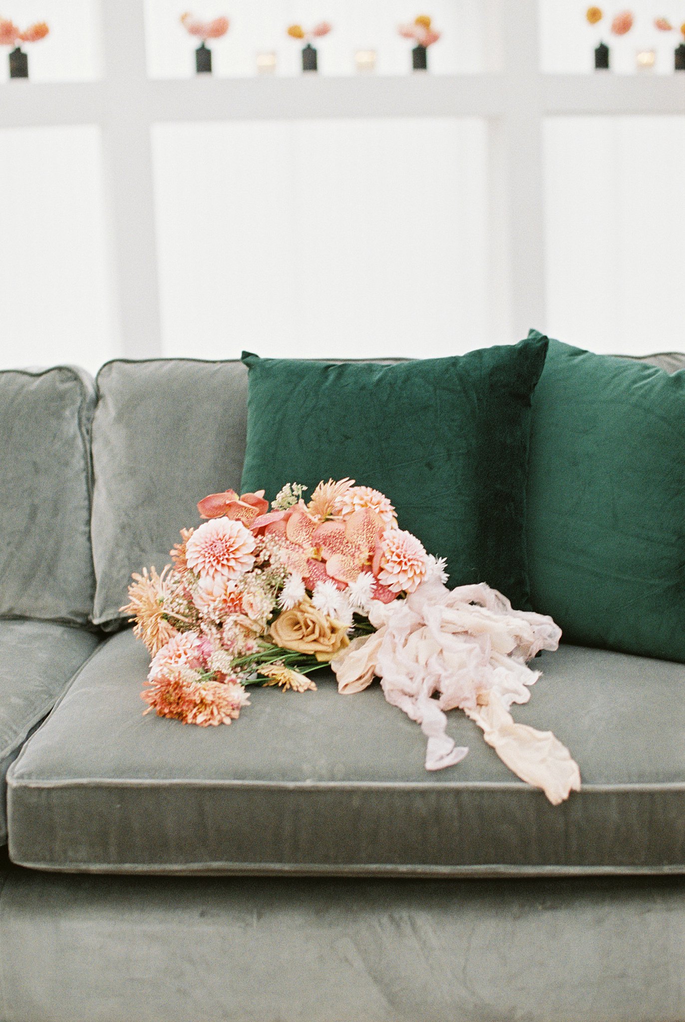 green velvet couch with peach dahlia bridal bouquet Austin, Texas wedding