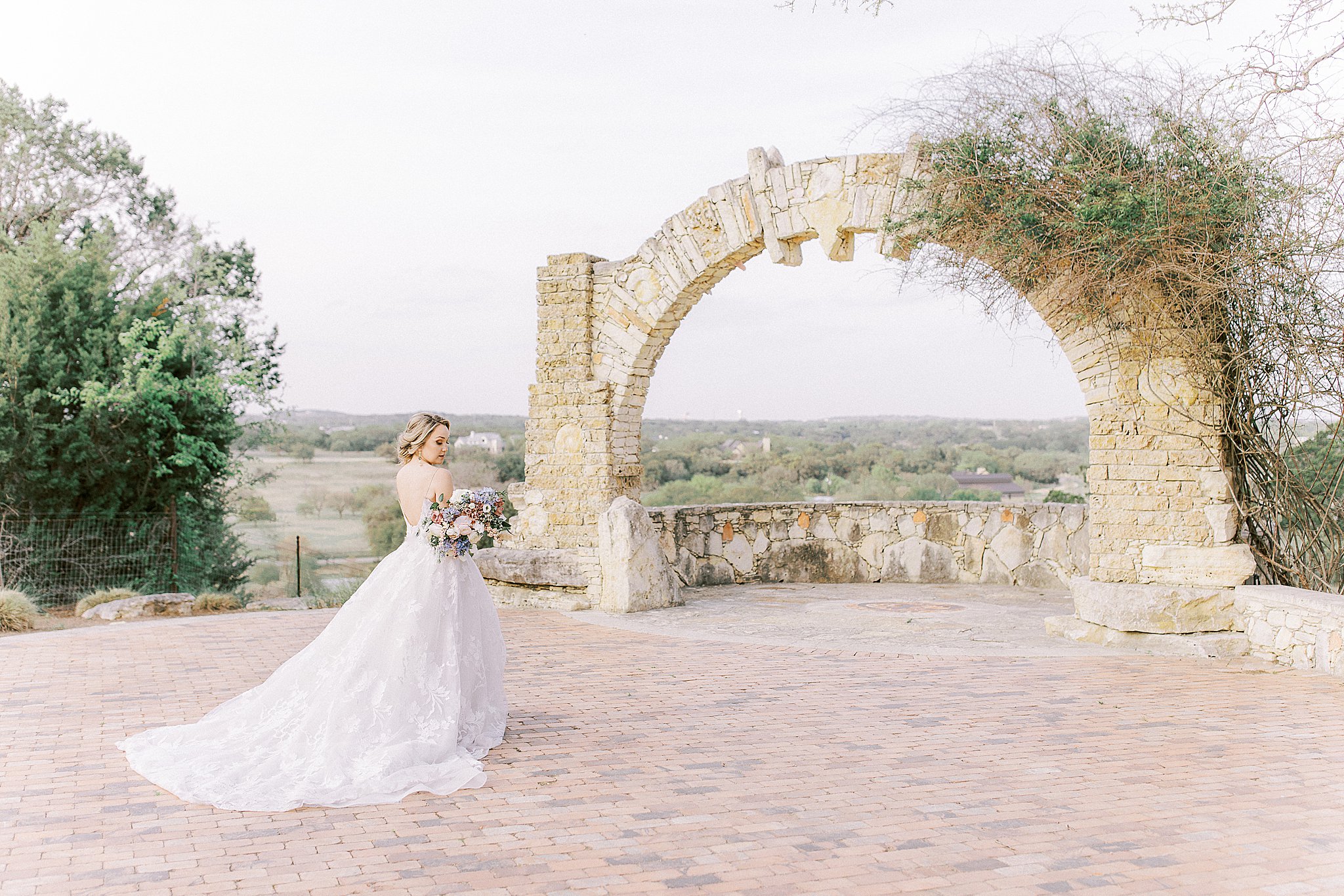 Austin bride, Camp Lucy brick terrace, stone archway wedding venue