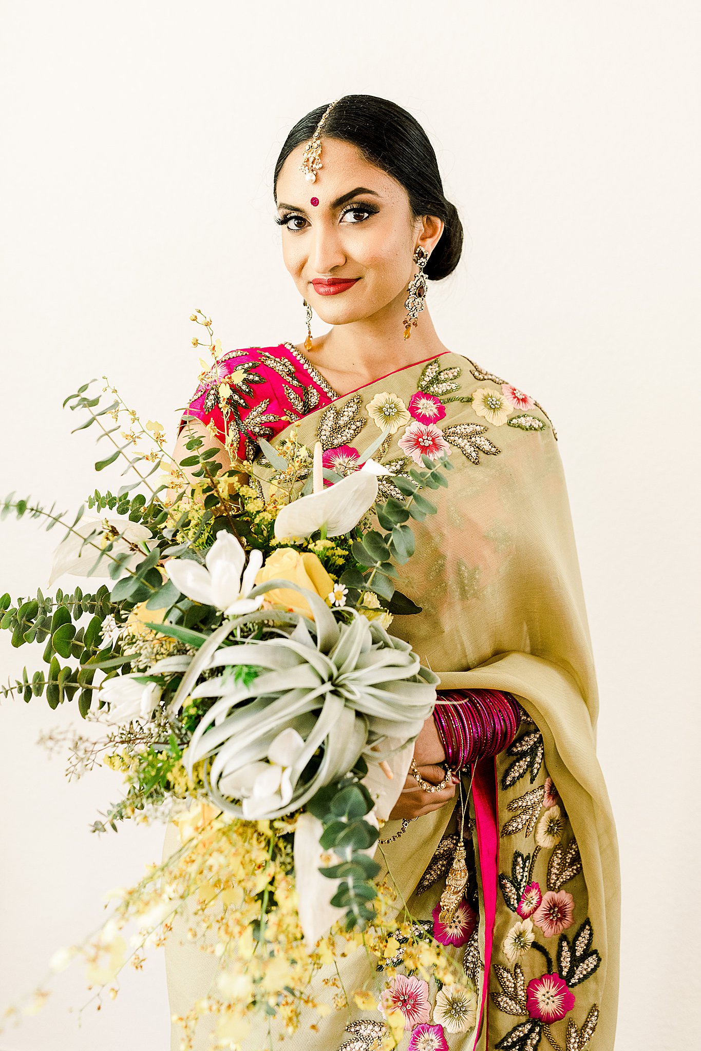 Stunning Indian bride in gown with dreamy floral embroidery holding succulent and Eucalyptus bouquet at Ma Maison, Texas